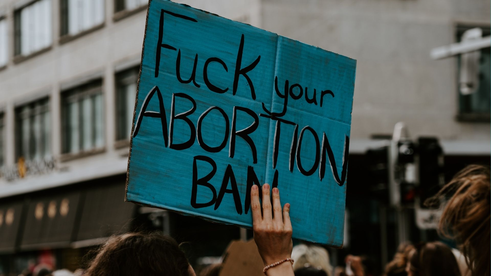 Pancarte de manifestation « Fuck your abortion ban » pour le droit à l’IVG à Zurich