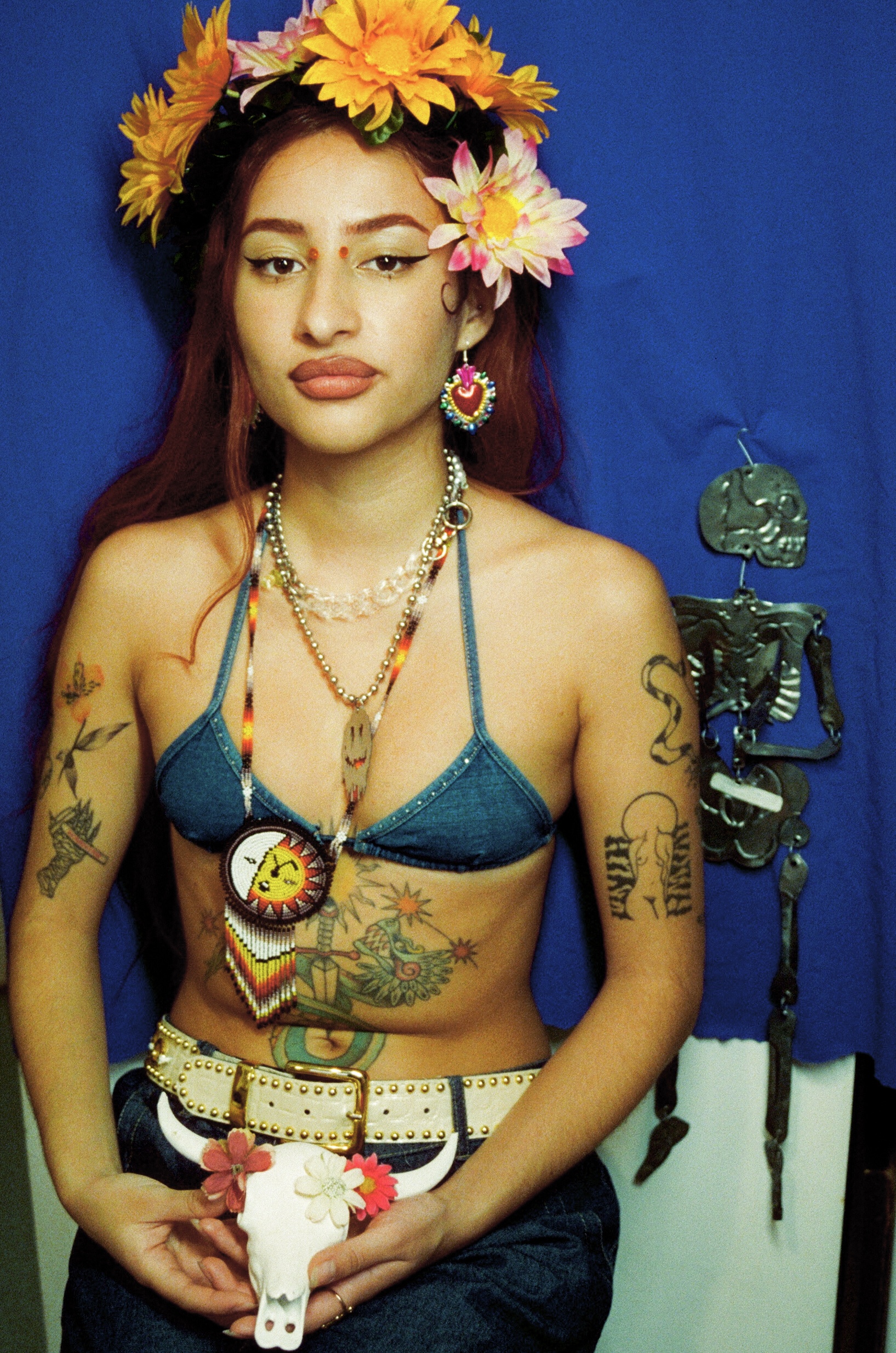 Tessa pose en haut de bikini et jean, le ventre orné d'un quetzalcoatl.