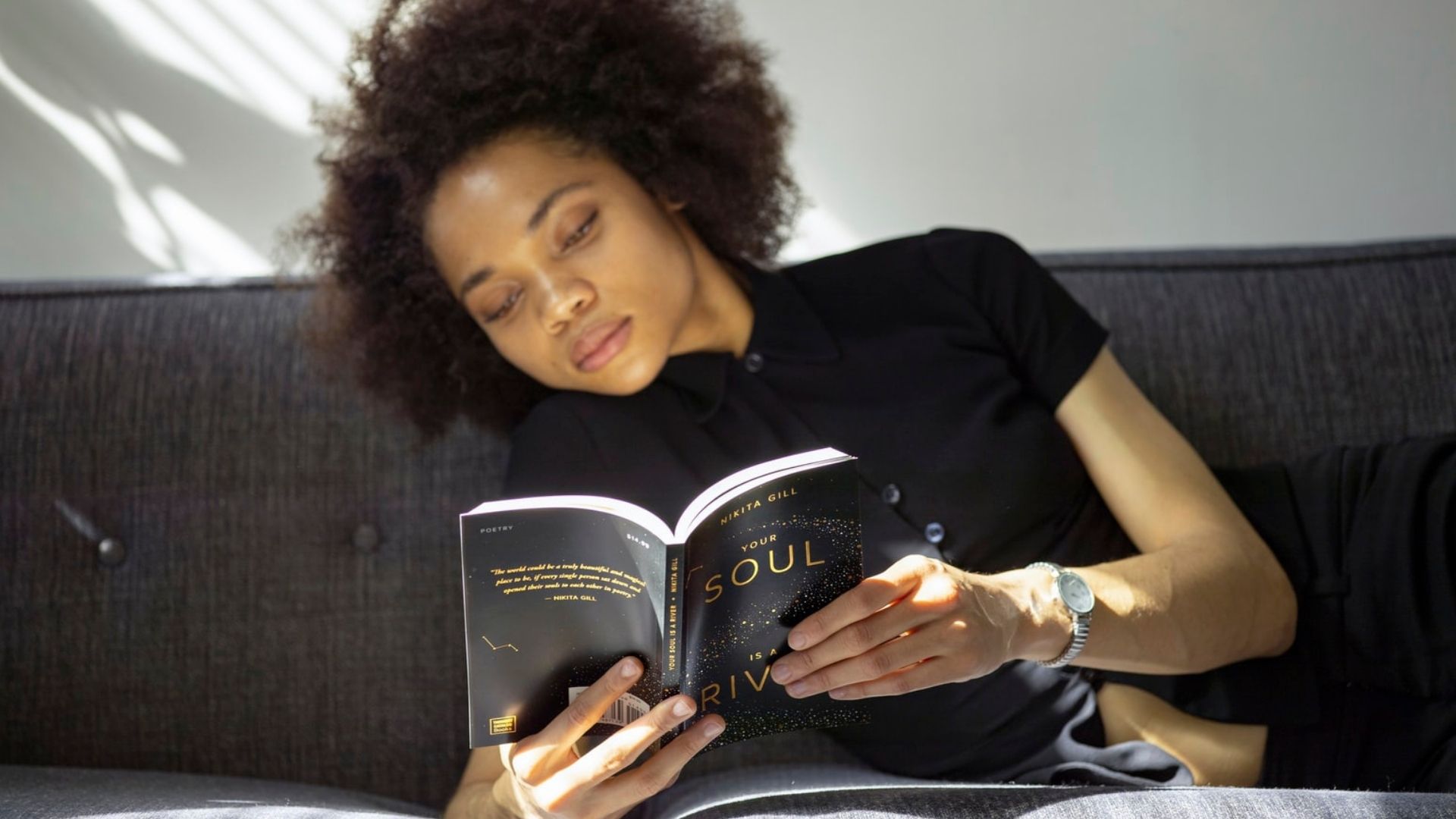 Une jeune femme noire lisant un roman.